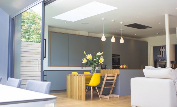 Complete kitchen refurbishment with white walls, large window, blue furniture and wooden floor