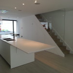 Large kitchen with white furniture, wooden stairs and worktop