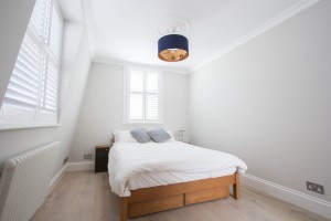 White bedroom with double bed and two windows