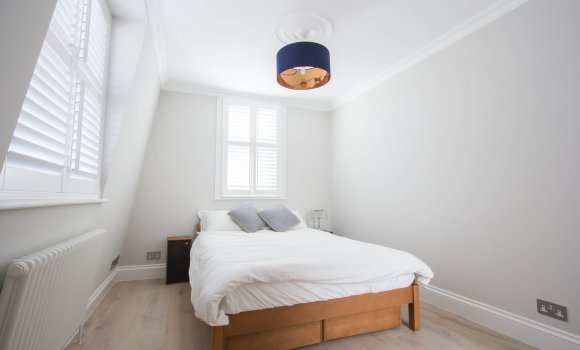 White bedroom with double bed and two windows