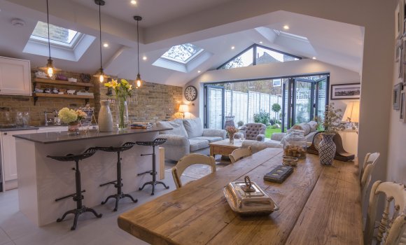 Completely refurbished dining room with white wooden furniture and roof windows